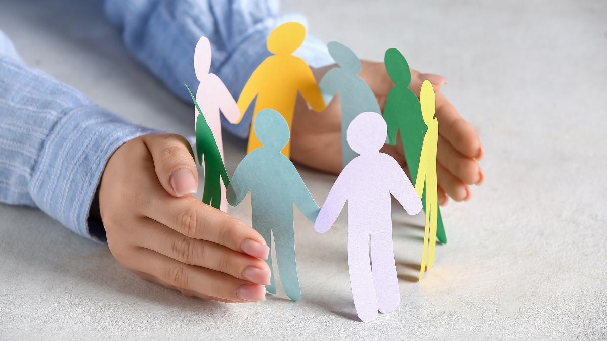 Homme qui maintient une couronne en papier de petits bonhommes de couleurs différentes